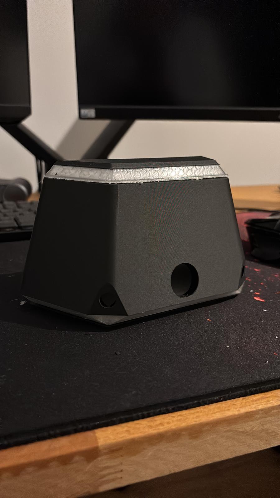 3D-printed dark enclosure with a light accent band and cut-out openings
